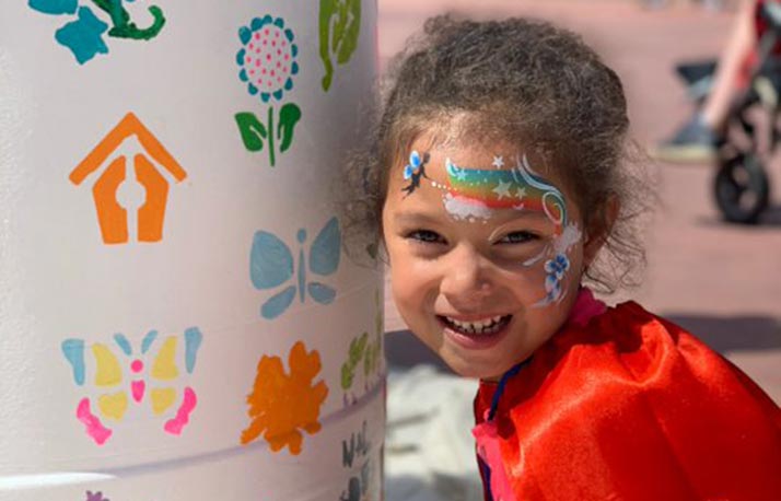 Girl next to rain barrel