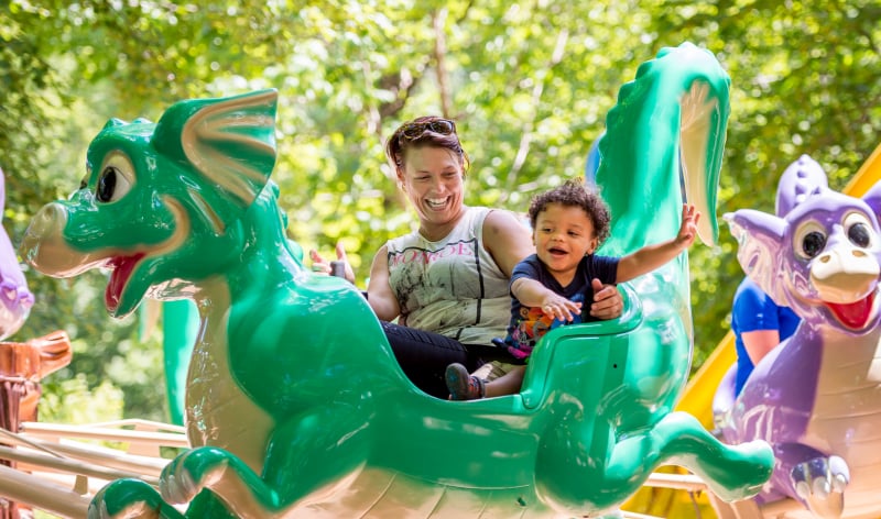 Adult and child on a children's dragon ride