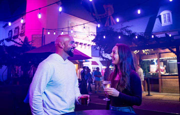 A man and a woman with beer outside of a bar