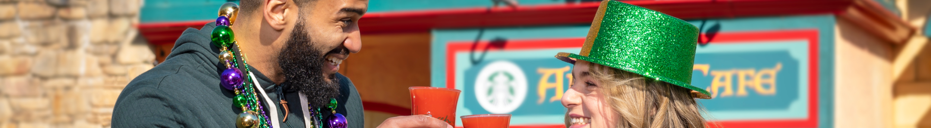 Two friends with drinks during Mardi Gras